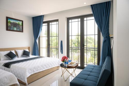 a bedroom with a bed and a blue couch at Khách Sạn The Sum in Tây Ninh