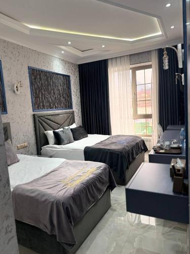 a hotel room with two beds and a desk at Panorama Resort Oghuz in Oğuz