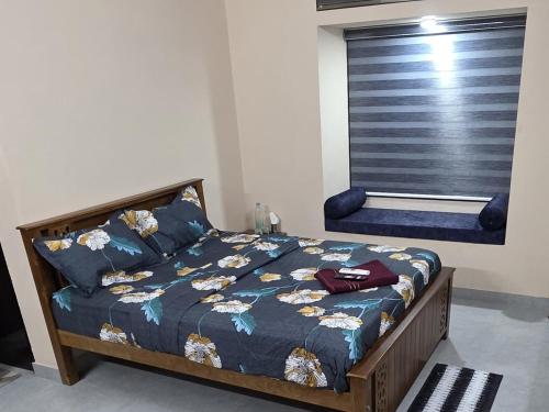 a bedroom with a bed with blue sheets and a window at Crystal Homestay in Trivandrum