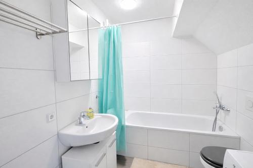 a bathroom with a sink and a toilet and a bath tub at Larooms Merseburg - Apartment NP62 - ServiceApartment für Geschäftsreisende in Merseburg