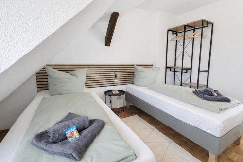 two beds in a room with white walls at Larooms Merseburg - Apartment NP62 - ServiceApartment für Geschäftsreisende in Merseburg
