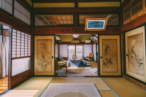 a room with wooden doors and a living room at 山形イチマルニマル in Miyajuku