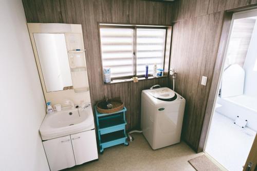 a small bathroom with a sink and a washing machine at 山形イチマルニマル in Miyajuku