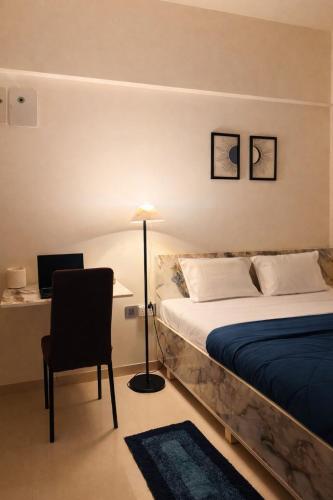 a bedroom with a bed and a chair and a lamp at Elegant 1 RK Studio Balewadi in Pune