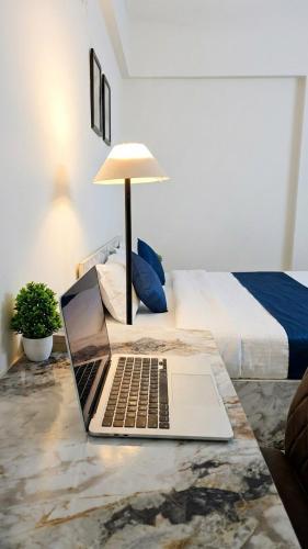 a laptop on a table next to a bed at Elegant 1 RK Studio Balewadi in Pune