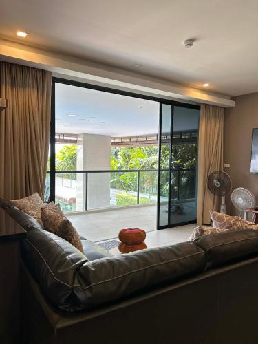 a leather couch in a living room with a large window at Escape Condominium By A property in Mae Pim