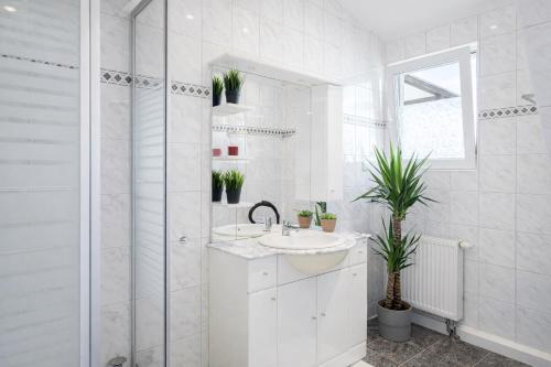 a white bathroom with a sink and a shower at Larooms Merseburg - Apartment LP01 - 2 Zimmer, 2 Einzelbetten, 1 Doppelbett, große Couch, Küche, Balkon, Waschmaschine in Merseburg