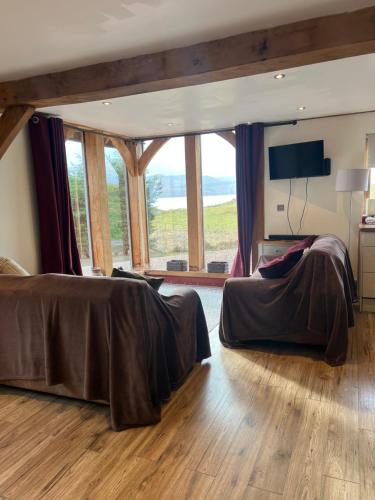a bedroom with a large bed and a large window at Tigh a Chabar in Lochaline