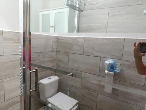 a person taking a picture of a bathroom with a toilet at 477 California Sands Chalets in Scratby