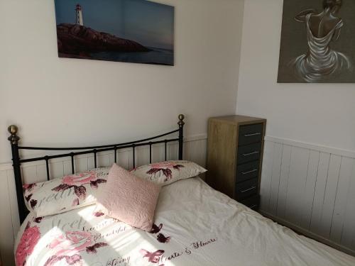 a bedroom with a bed and a dresser and a lighthouse at 477 California Sands Chalets in Scratby