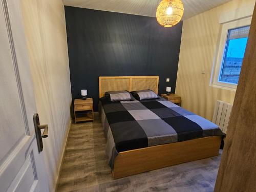 una camera da letto con un letto con un piumone bianco e nero di Ty Koad Penhoat a Plourivo