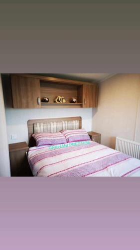a bedroom with a large bed with wooden cabinets at Grahams Prestige Craig Tara in Minishant