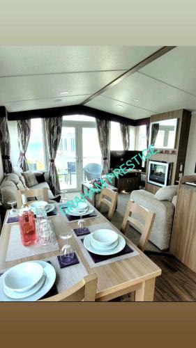 a dining table and chairs in a living room at Grahams Prestige Craig Tara in Minishant