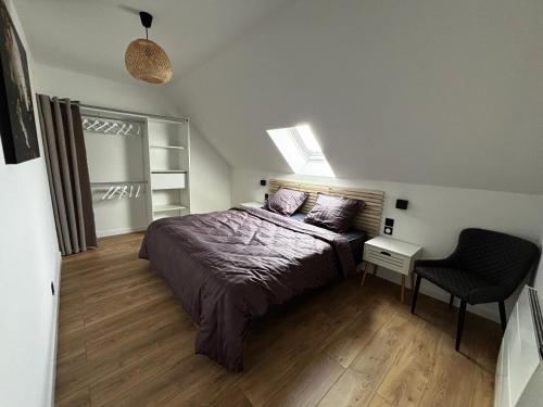 a bedroom with a bed and a chair in it at L Orée des Thermes in Saint-Amand-les-Eaux