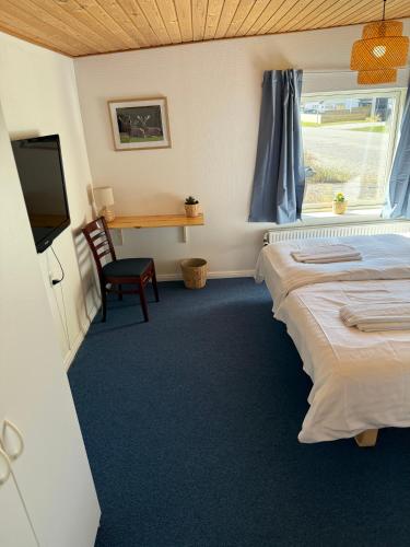 a room with a bed and a desk and a television at VØ Budget Drop Inn in Thisted