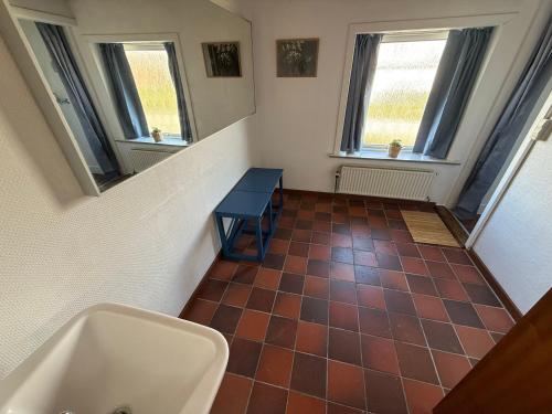 a bathroom with a tub and a sink and windows at VØ Budget Drop Inn in Thisted