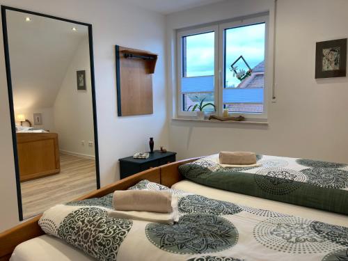 two beds in a room with a mirror at Andi's Auszeit in Dörpen