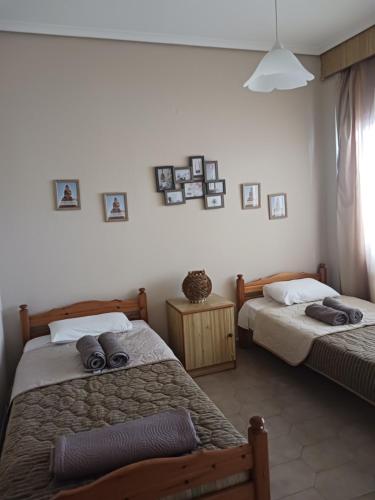 a bedroom with two beds and pictures on the wall at Anastasios Room's in Olympic Beach