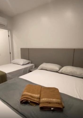 a room with two beds with a towel on them at Condomínio Vila Eco Barra apto 215 in Barra Grande