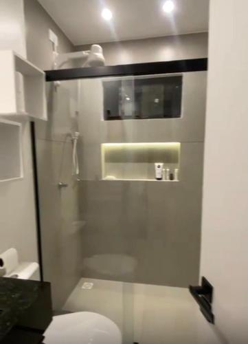 a bathroom with a toilet and a glass door at Condomínio Vila Eco Barra apto 215 in Barra Grande