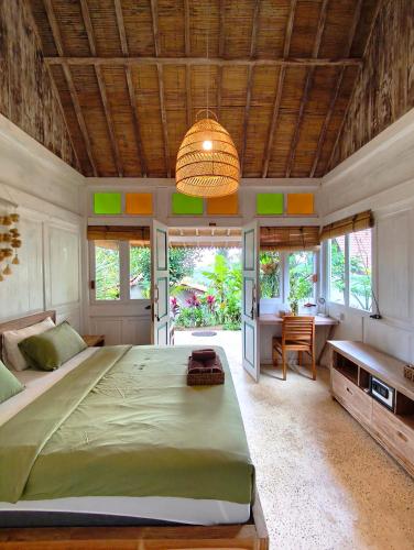 a bedroom with a large bed and a desk at Purwa Ijen in Banyuwangi