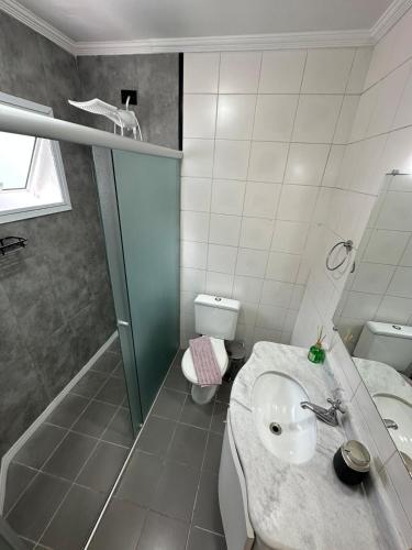 a bathroom with a sink and a toilet at Cobertura Premium com Piscina Exclusiva in Guarujá