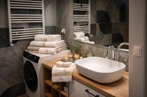 a bathroom with a sink and a washing machine at MODERN APARTAMENT Walendów Park in Walendów