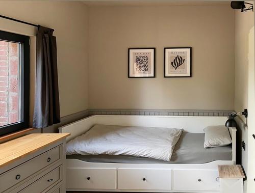 a bed in a bedroom with two pictures on the wall at de Relliner Hüs in Heringsdorf
