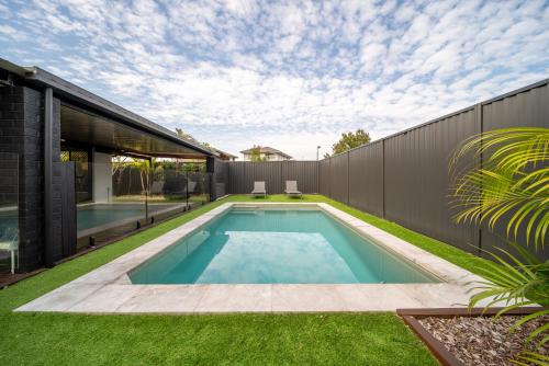 a swimming pool in the backyard of a house at 3BR Little Coastal Boho Home - Neverending Summer Fun near Themeparks & close to M1 exit in Pimpama