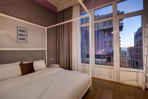 a bedroom with a bed and a large window at Colors Urban Hotel Thessaloniki in Thessaloniki