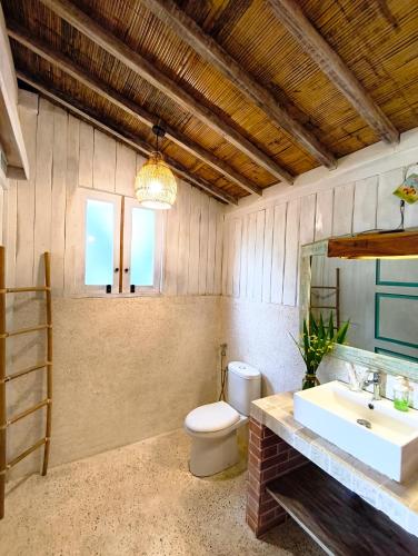 a bathroom with a toilet and a sink and a mirror at Purwa Ijen in Banyuwangi