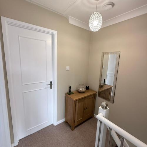 a bathroom with a white door and a mirror at 30 Waterside in Corton