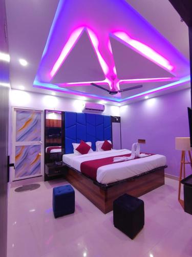 a bedroom with a large bed with purple lighting at Hotel Midnight in Muzaffarpur