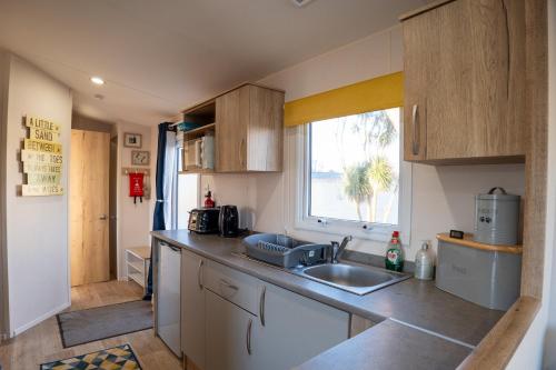 a small kitchen with a sink and a window at B3 Sunny Tides in Brixham