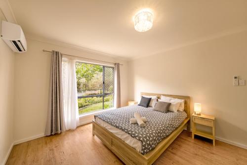 a bedroom with a bed and a large window at 3BR Coomera Duplex 2- Cute & Cosy Home Close to Theme Park in Gold Coast