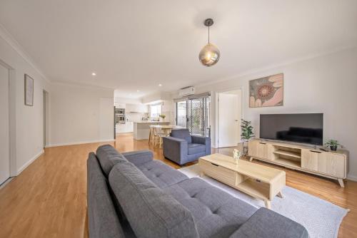 a living room with a couch and a tv at 3BR Coomera Duplex 2- Cute & Cosy Home Close to Theme Park in Gold Coast