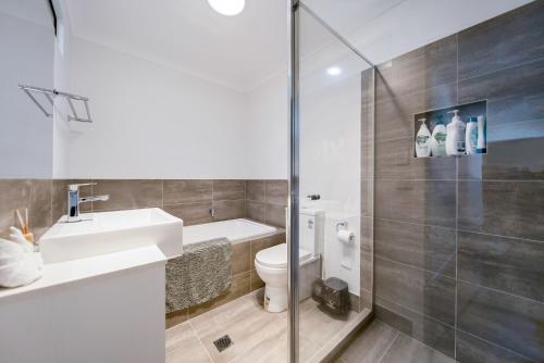 a bathroom with a toilet and a sink and a shower at 3BR Coomera Duplex 2- Cute & Cosy Home Close to Theme Park in Gold Coast