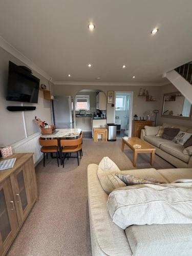 a large living room with a couch and a table at 30 Waterside in Corton