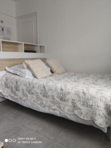 a bed in a white room with pillows on it at La Suite by Nath in Calais