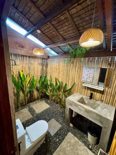 a bathroom with a toilet and a sink at Fika Siargao - Cozy Island Home in General Luna in General Luna