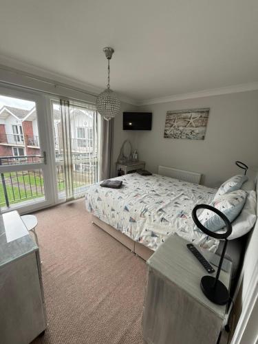 a bedroom with a bed and a large window at 30 Waterside in Corton