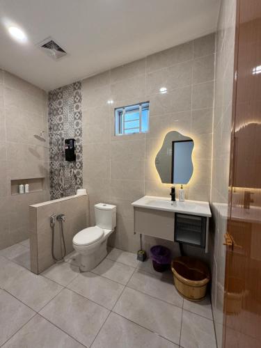 a bathroom with a toilet and a sink and a mirror at Rooma Bali Jeram in Kuala Selangor