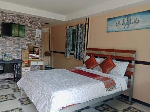 a bedroom with a bed and a tv on the wall at สมหวัง โฮมสเตย์ in Ban Khuan Suan