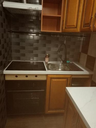 a small kitchen with a sink and a sink at Chmurka in Bęczków