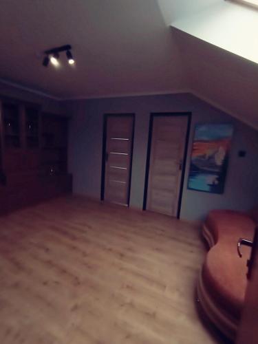 an empty room with two doors and a wooden floor at Chmurka in Bęczków