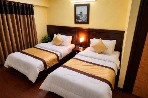 a hotel room with two beds in a room at Al Makkah Hotel in Karachi