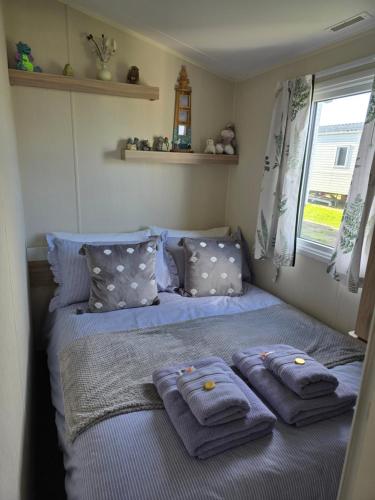 a bedroom with two blue towels on a bed at Seaside Caravan Home in Reighton