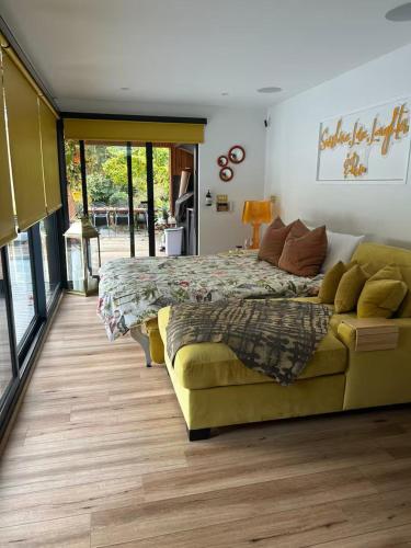 a bedroom with a bed and a couch at Chiswick Garden Studio with Outdoor Pool and Boutique Finish in London