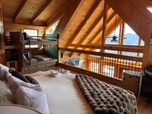 a large bed in a room with a large window at Classy Bear Cabin - Summit Views of Ober Mountain, Hot Tub, 3 King Beds, 2 Mi to Downtown in Gatlinburg