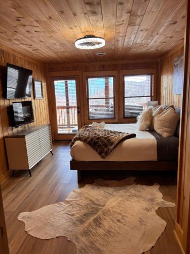 a bedroom with a large bed in a wooden room at Classy Bear Cabin - Summit Views of Ober Mountain, Hot Tub, 3 King Beds, 2 Mi to Downtown in Gatlinburg